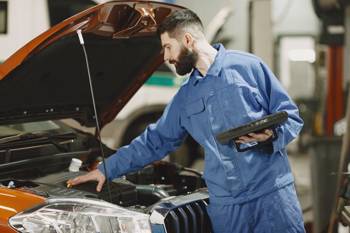 Fundi akichunguza injini ya gari — MKUMBILWA CAR AUTOSERVICE